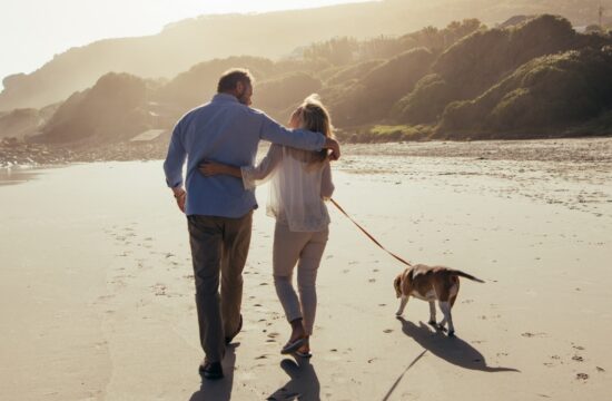 couple walking their dog on the beach