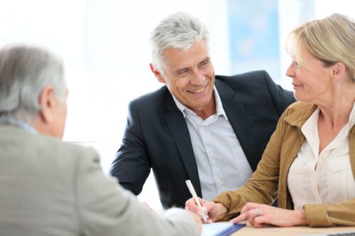 couple signing a paper for their wealth consultant